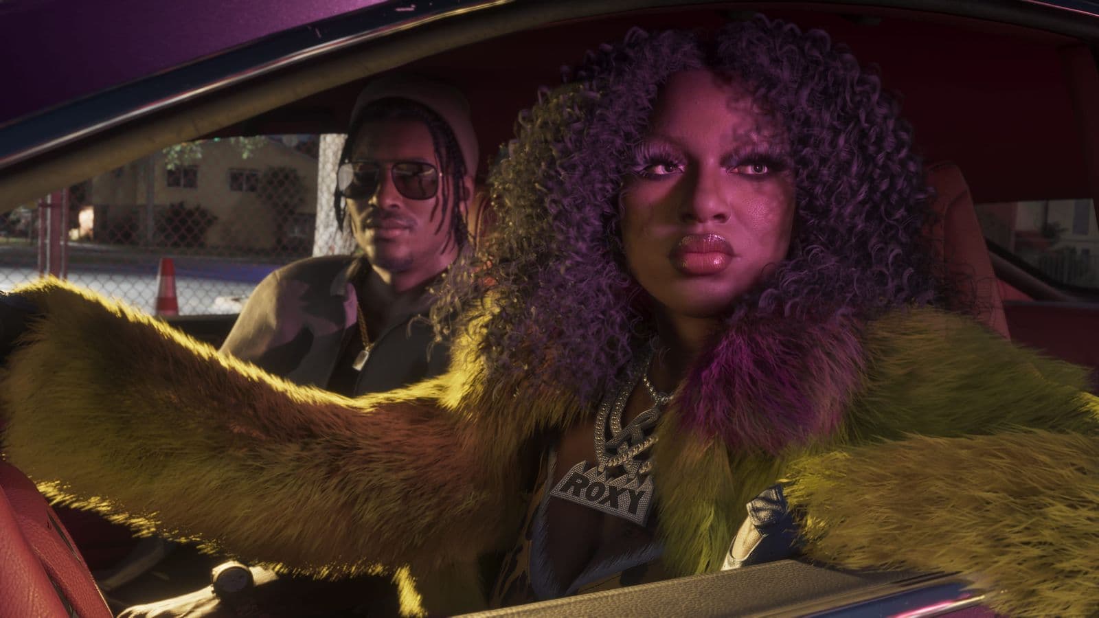 Roxy of Real Dimez, in a green fur coat, behind the wheel of a car with Dre’Quan Priest in the passenger seat